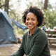 A smiling woman outdoors, representing a satisfied customer for an adventure-ready product.